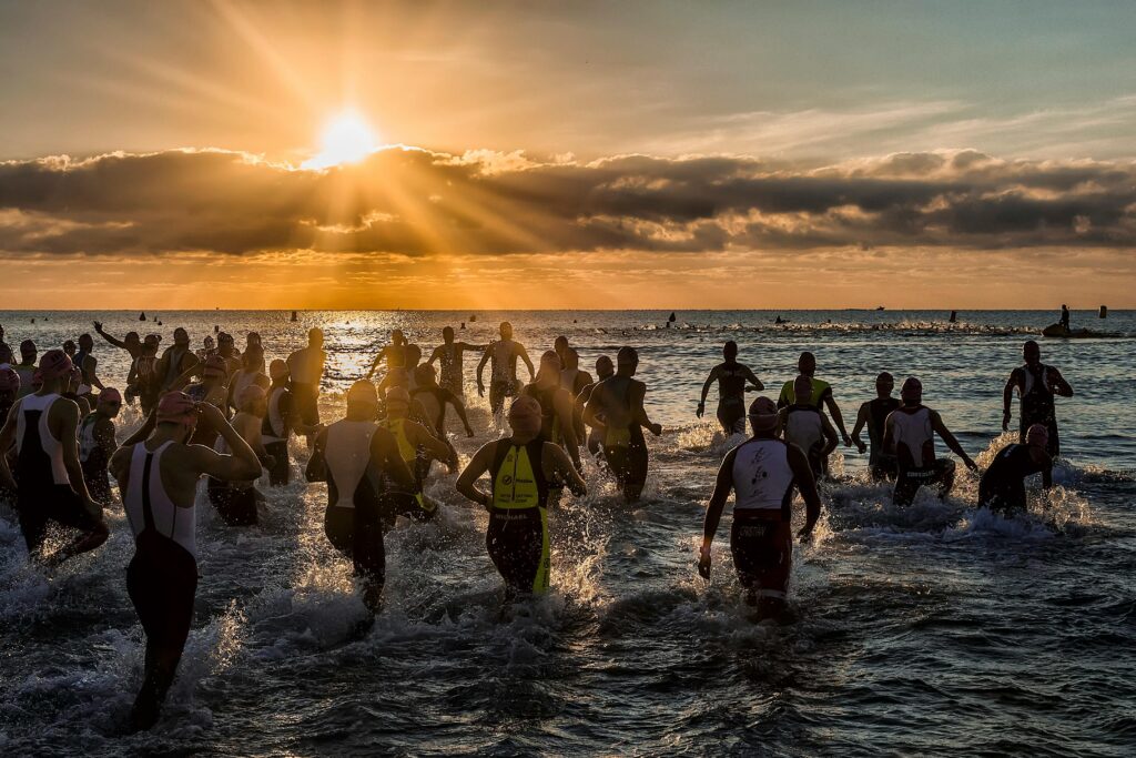 Captured during a triathlon event, athletes enter the sea at sunrise in Alicante, Spain.